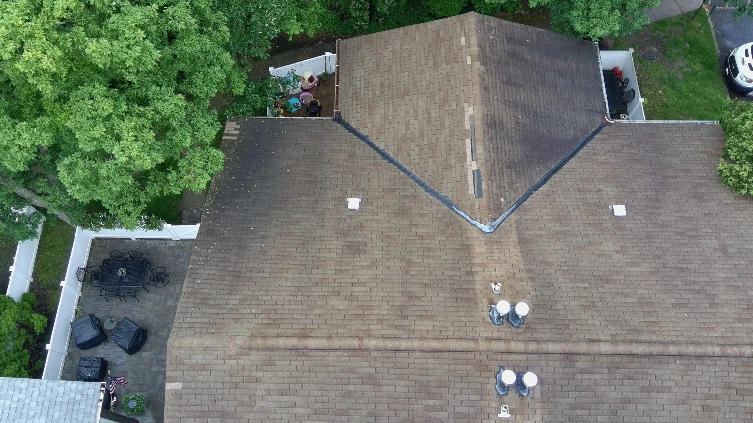 Heavy tar repairs at valleys and penetrations found during roof inspection in Medford, NY