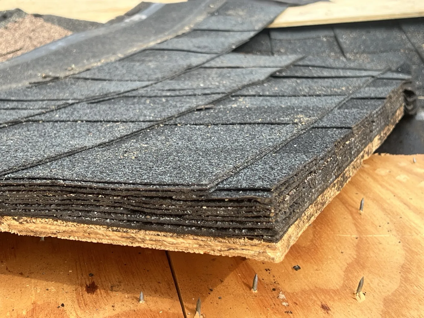 Multiple layers of older asphalt roofing exposed during roof work